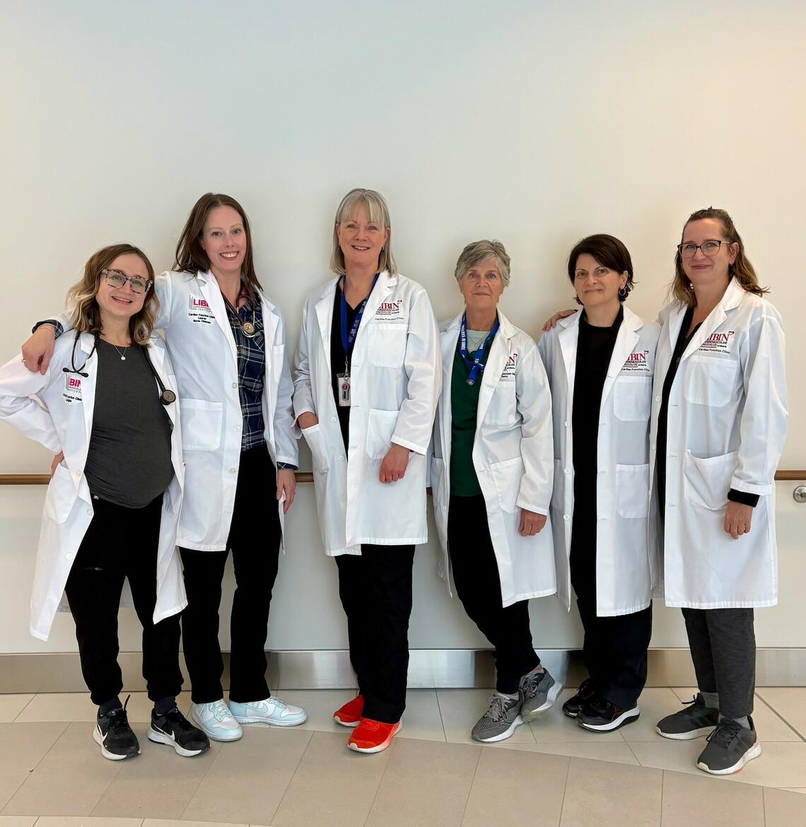 Nurses wearing lab coats pose